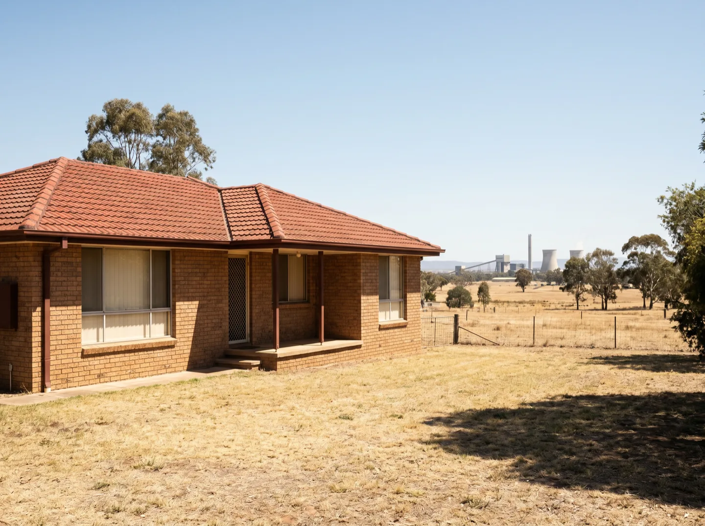 A brick-veneer home near Singleton with power-station cooling towers in the distance